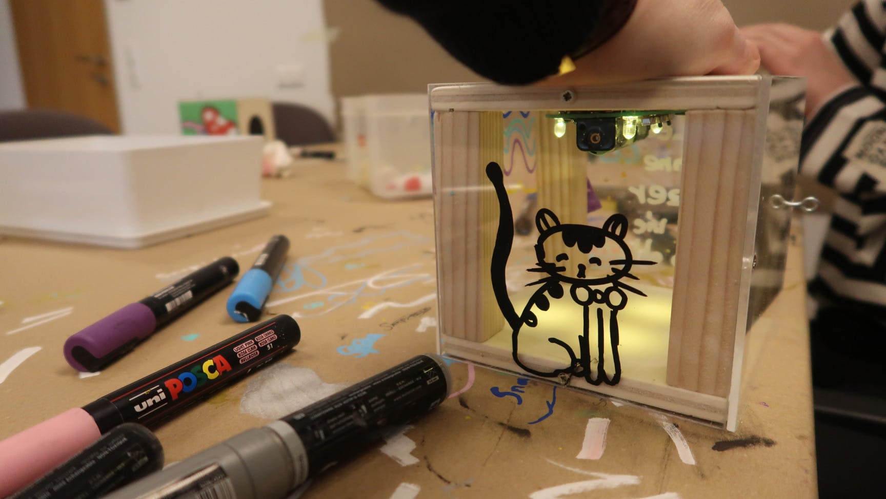 Solarlampe mit einer gezeichneten Katze darauf und ein paar Stifte.