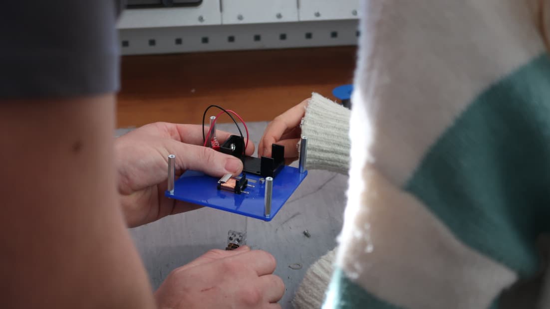 Zwei Hände halten ein Modell.