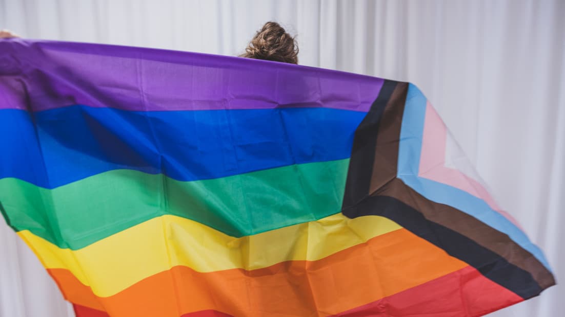Eine Person hält eine Progess Flag