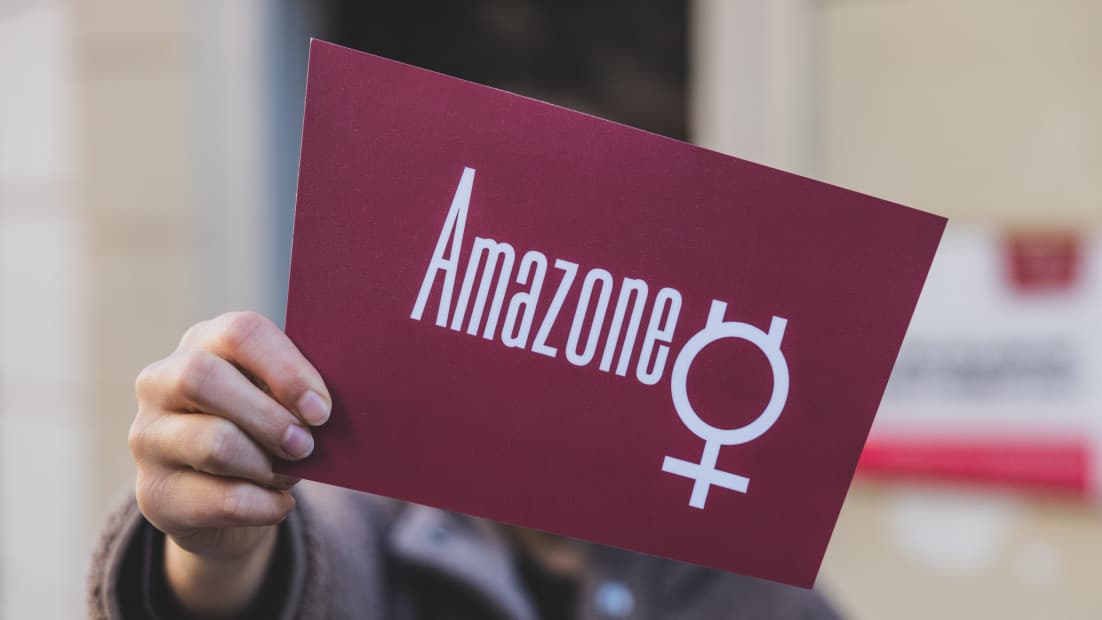 Person hält ein großes Amazone Logo in die Kamera