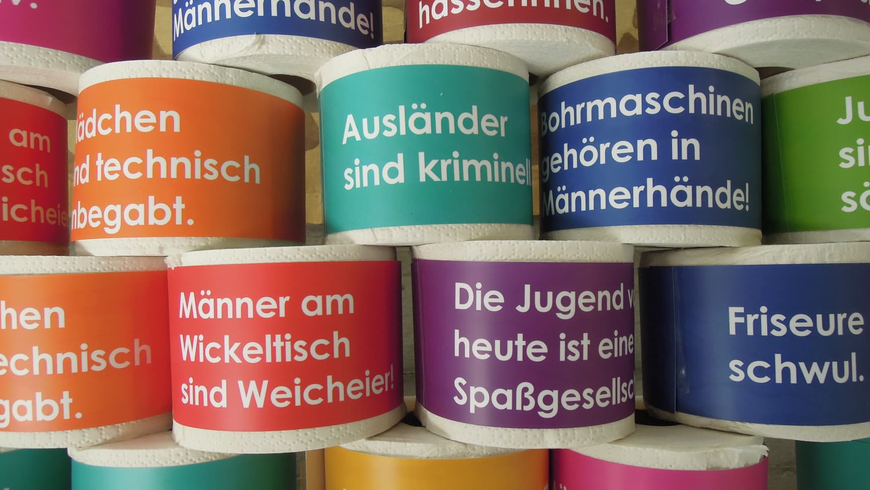 Aufgestapelte Klorollen mit Aufschriften wie z.B. Männer am Wickeltisch sind Weicheier oder Die Jugend von heute ist eine Spaßgesellschaft.