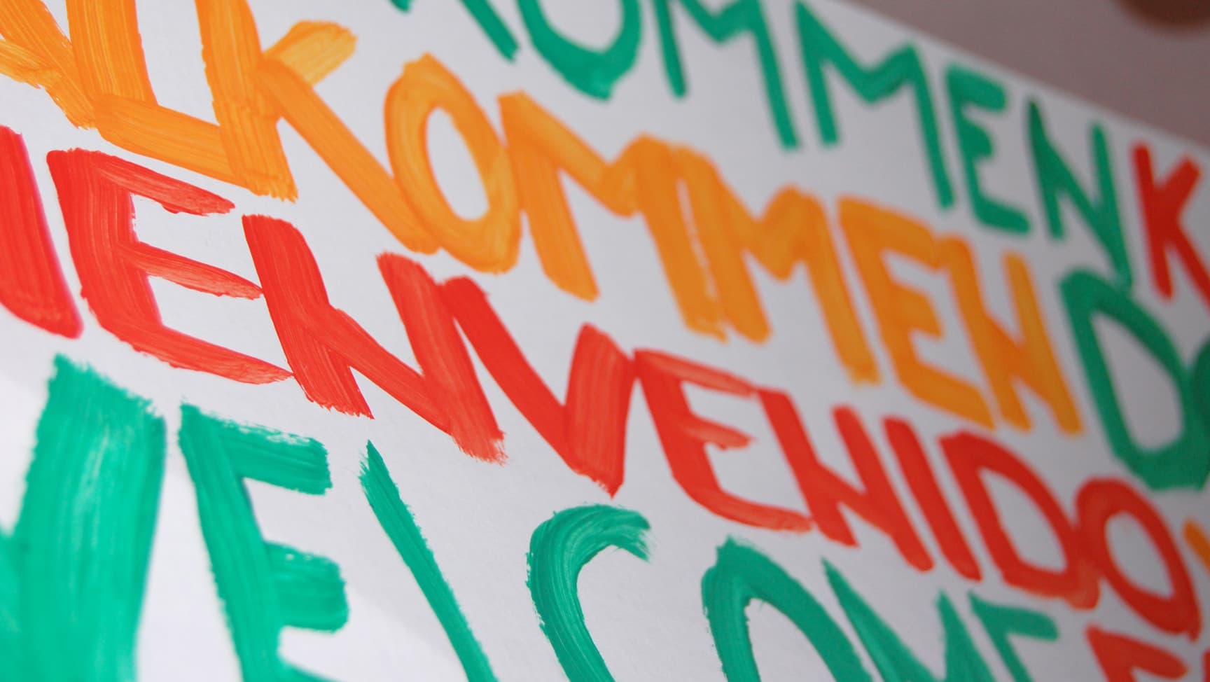 Schild mit dem Wort Willkommen in verschiedenen Sprachen