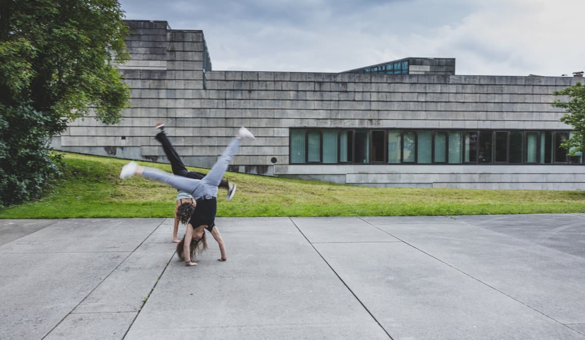 Zwei Jugendliche schlagen ein Rad.