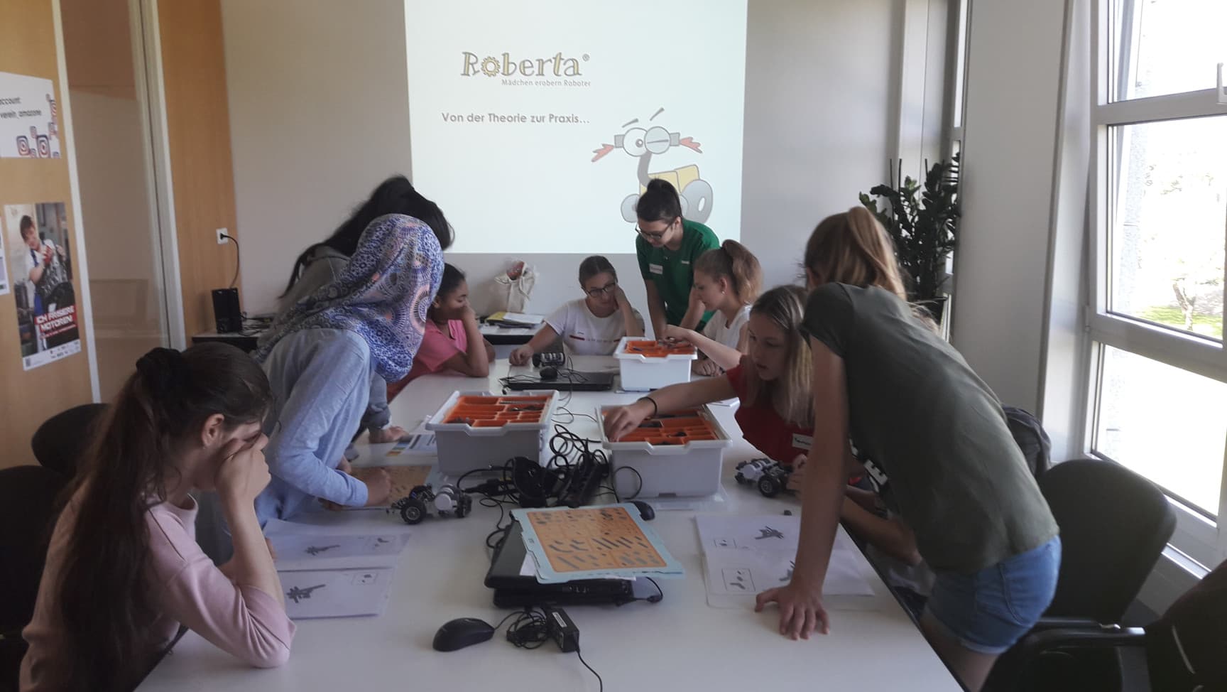 Workshopsituation mit Schülerinnen*, die Lego Robotern zusammenbauen