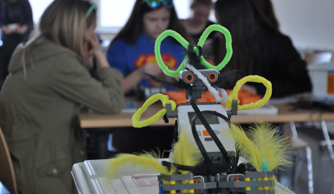 Eine Roberta im Vordergrund, dahinter eine sitzende Personengruppe.