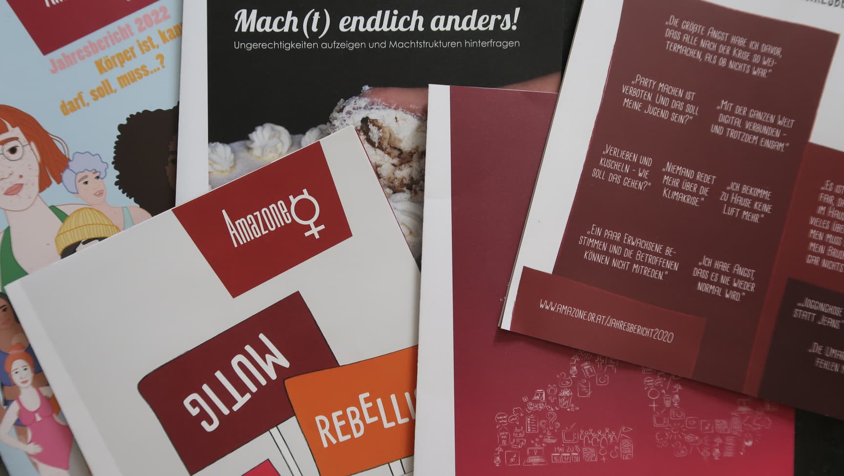 Fünf unterschiedliche Jahresberichte des Vereins Amazone liegen auf dem Boden.
