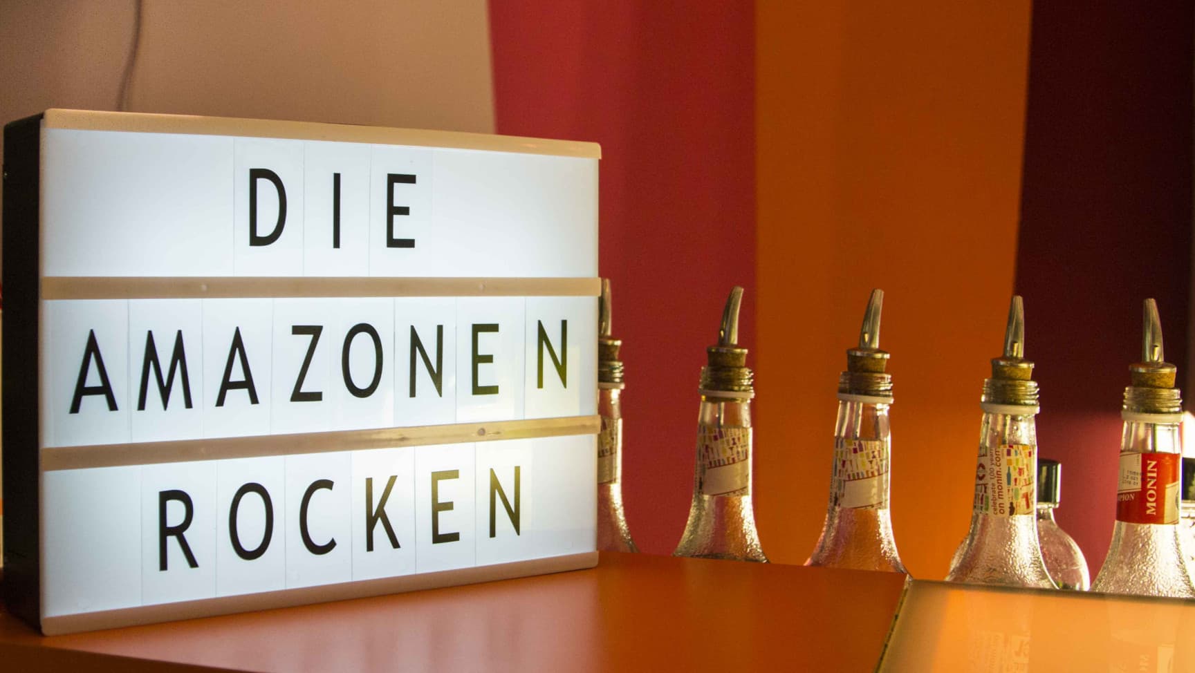 "Die Amazonen rocken" ist auf einem Board, das an der amazoenBAR steht.